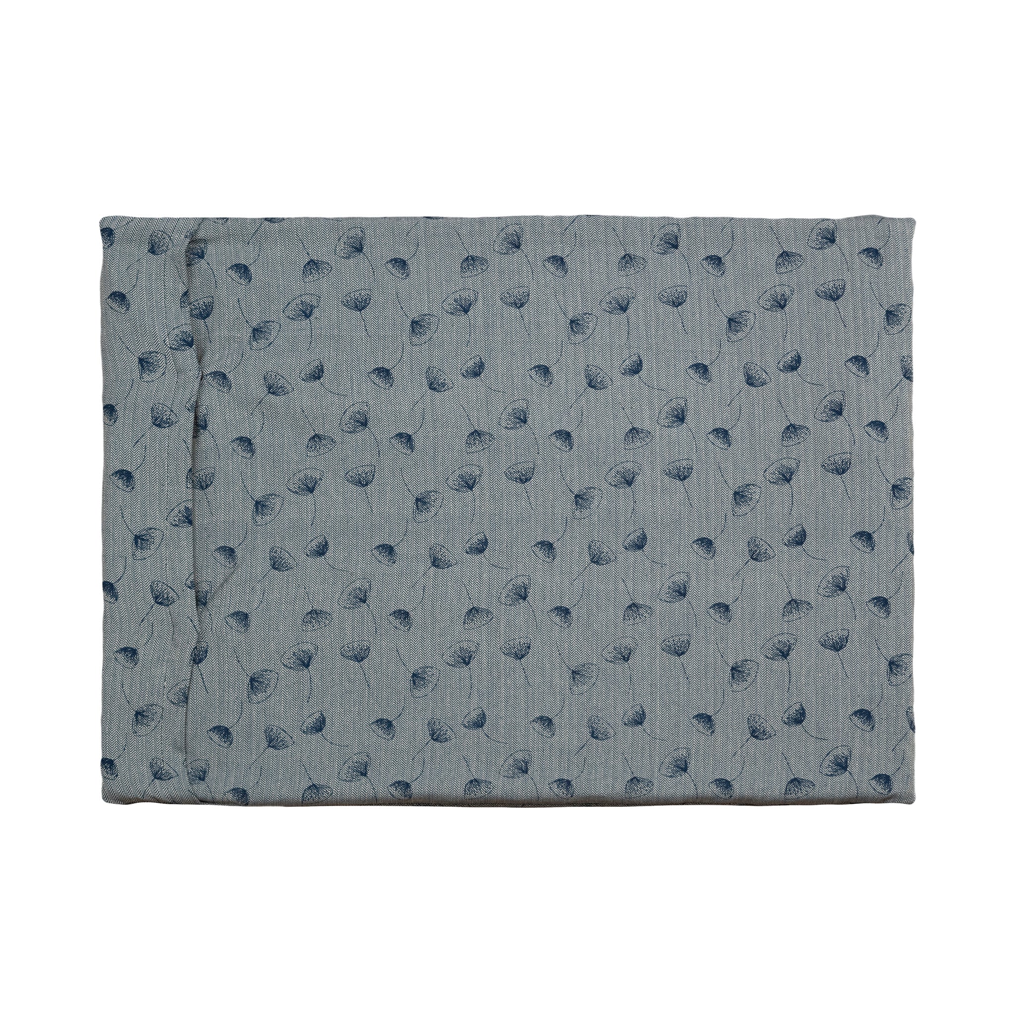A Chimney Sheep Luxury felted wool dog bed. The bed is large and rectangular. This luxury wool dog bed is placed onto a white background. The organic cotton cover is patterned. The pattern is blue with dark blue flowers.