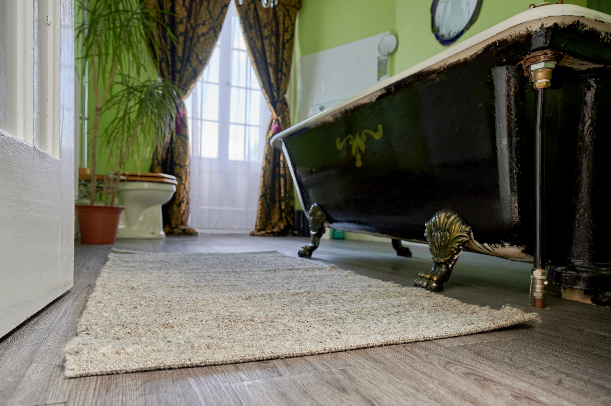 Herdwick wool rug on tiled bathroom floor next to bath for a luxury bath mat