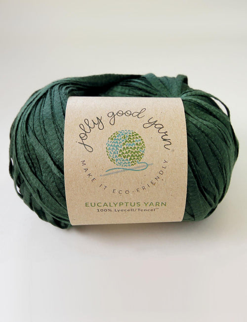 Yellow yarn ball with a label on a light gray background