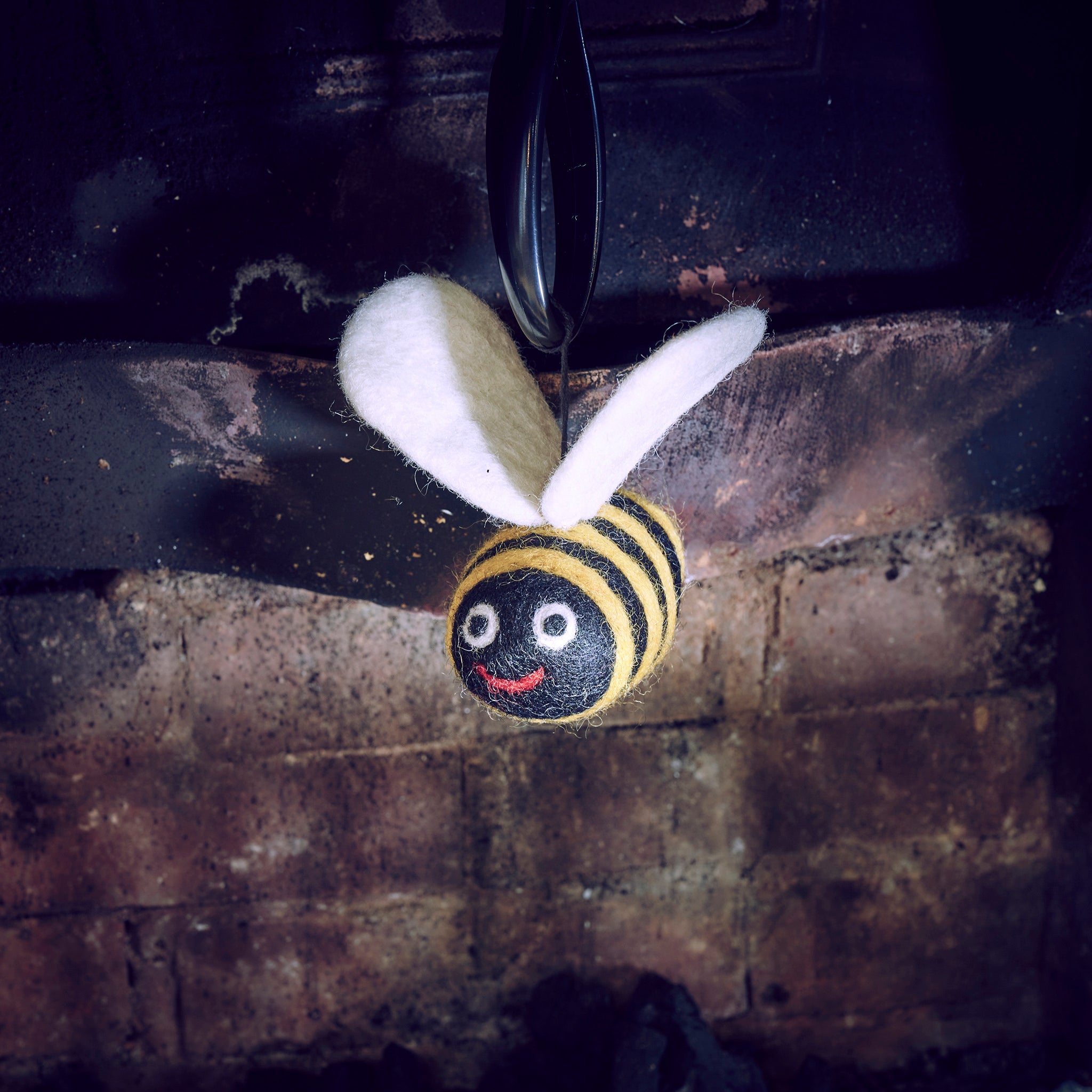 woolly felted bee dangle in fireplace