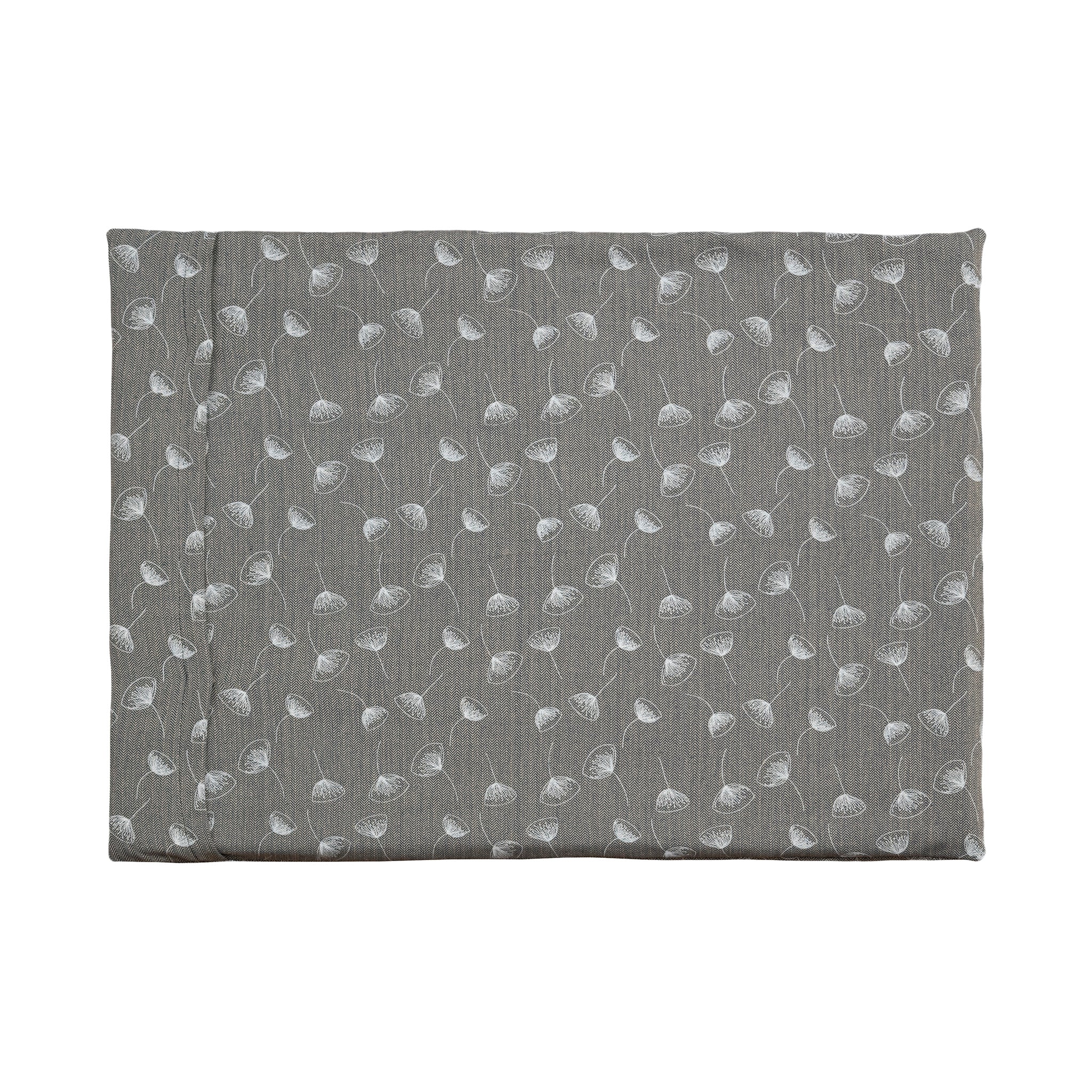 A Chimney Sheep Luxury felted wool dog bed. The bed is large and rectangular. This luxury wool dog bed is placed onto a white background. The organic cotton cover is patterned. The pattern is grey with white flowers.