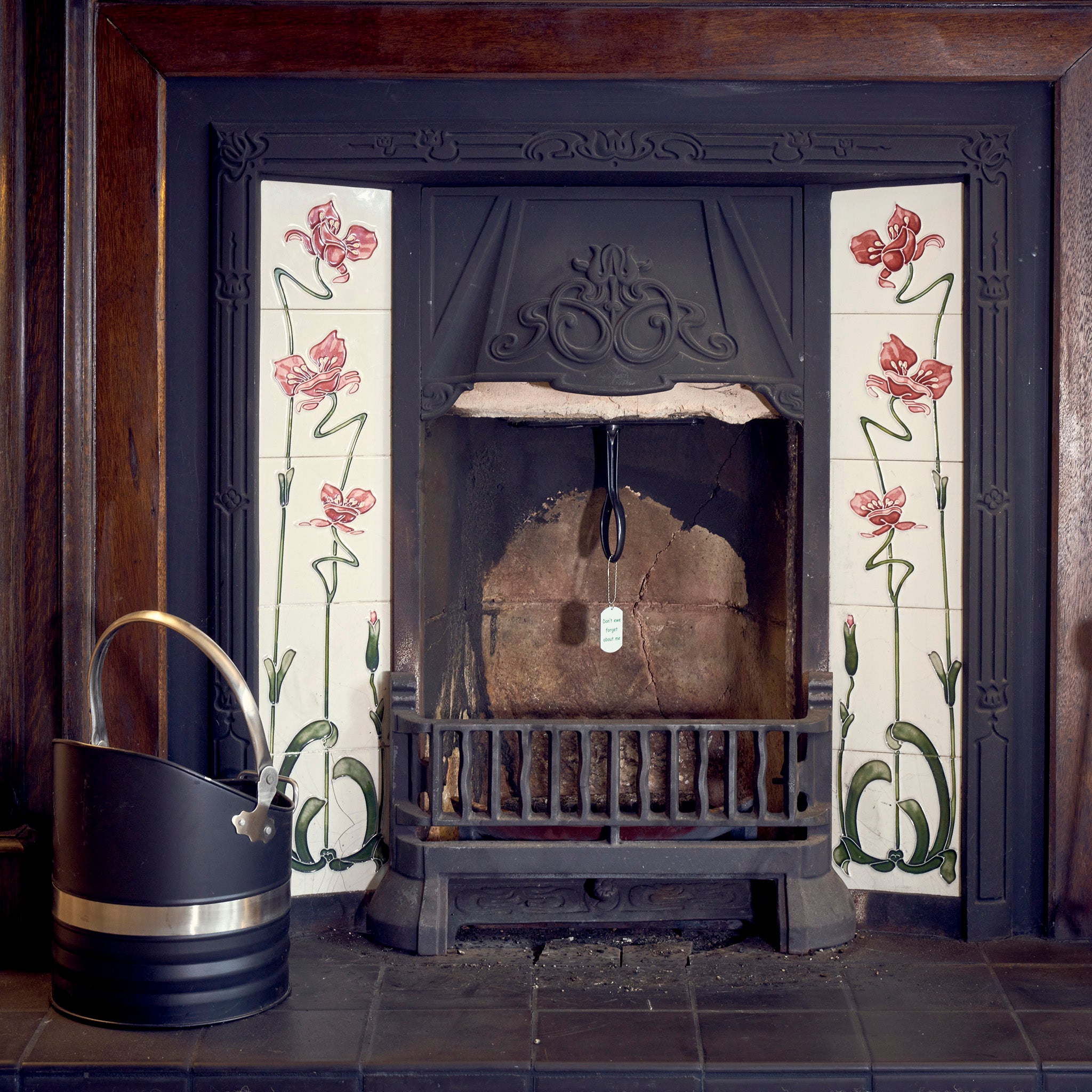 A Chimney Sheep in a fireplace with the handle and safety tag visible.