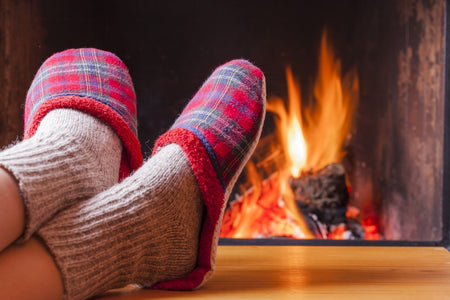 Tarten Slippers being worn by a burining fire.
