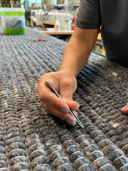 Handwoven British wool rug being checked