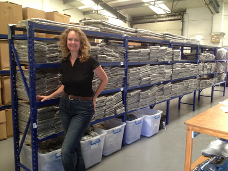 Sally owner of Chimney Sheep - standing by full shelves of Chimney Sheep