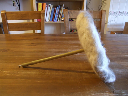 A prototype chimney sheep made with felted wool and a bamboo handle