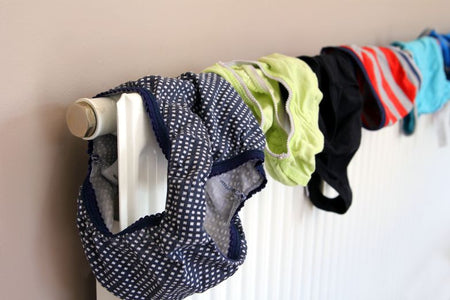 line of pants hung on a radiator causing damp in the home