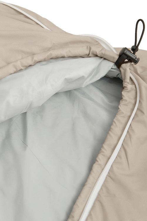 A beige mummy-style sleeping bag with a white zipper and small red logo details, shown against a plain white background.