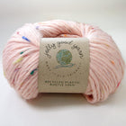 Pink yarn with colorful speckles and a label on a white background