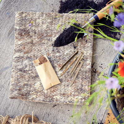 Bag of bamboo garden pegs with two pegs in front on a white background, featuring 'NEW AND IMPROVED' text at the top.