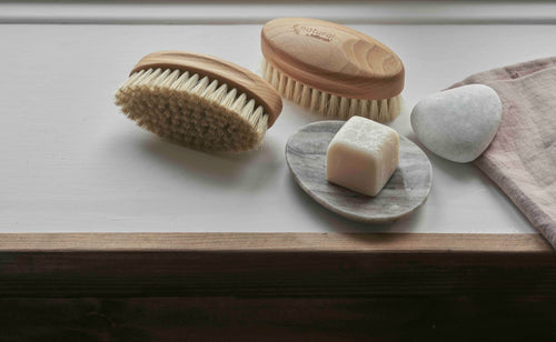 Wooden nailbrush with bristles on a marble background