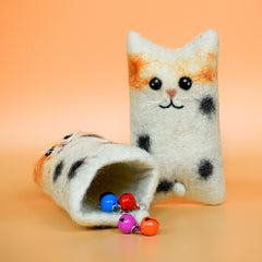 A white hoomans friends felted wool natural cat toy placed on an orange background thumbnail