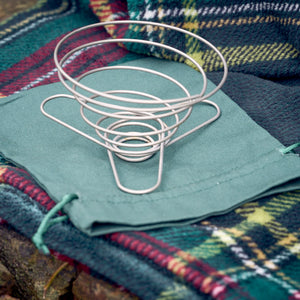 Portable wire coffee dripper on top of green organic cotton carry pouch