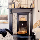 Wool chimney blocker handle with safety tag hanging down from inside a fireplace.