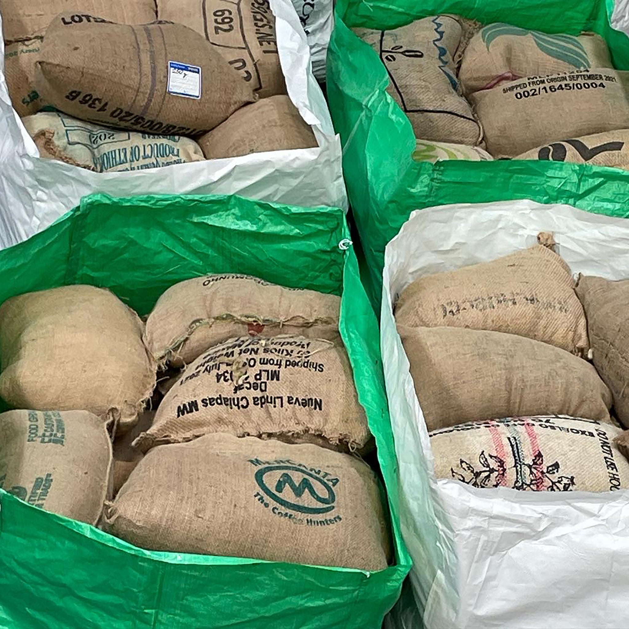 Green and white wool bags full of coffee sack cushions. 