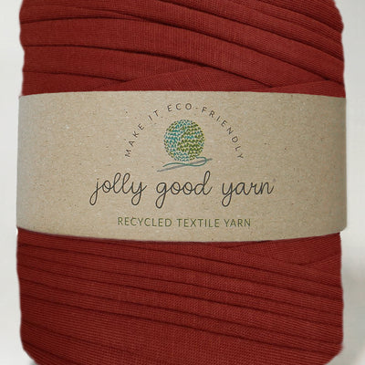 Red yarn ball with a beige label on a white background