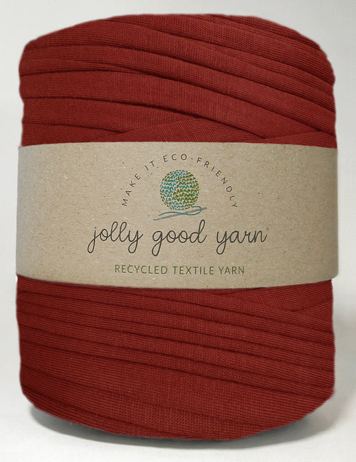 Red yarn ball with a beige label on a white background