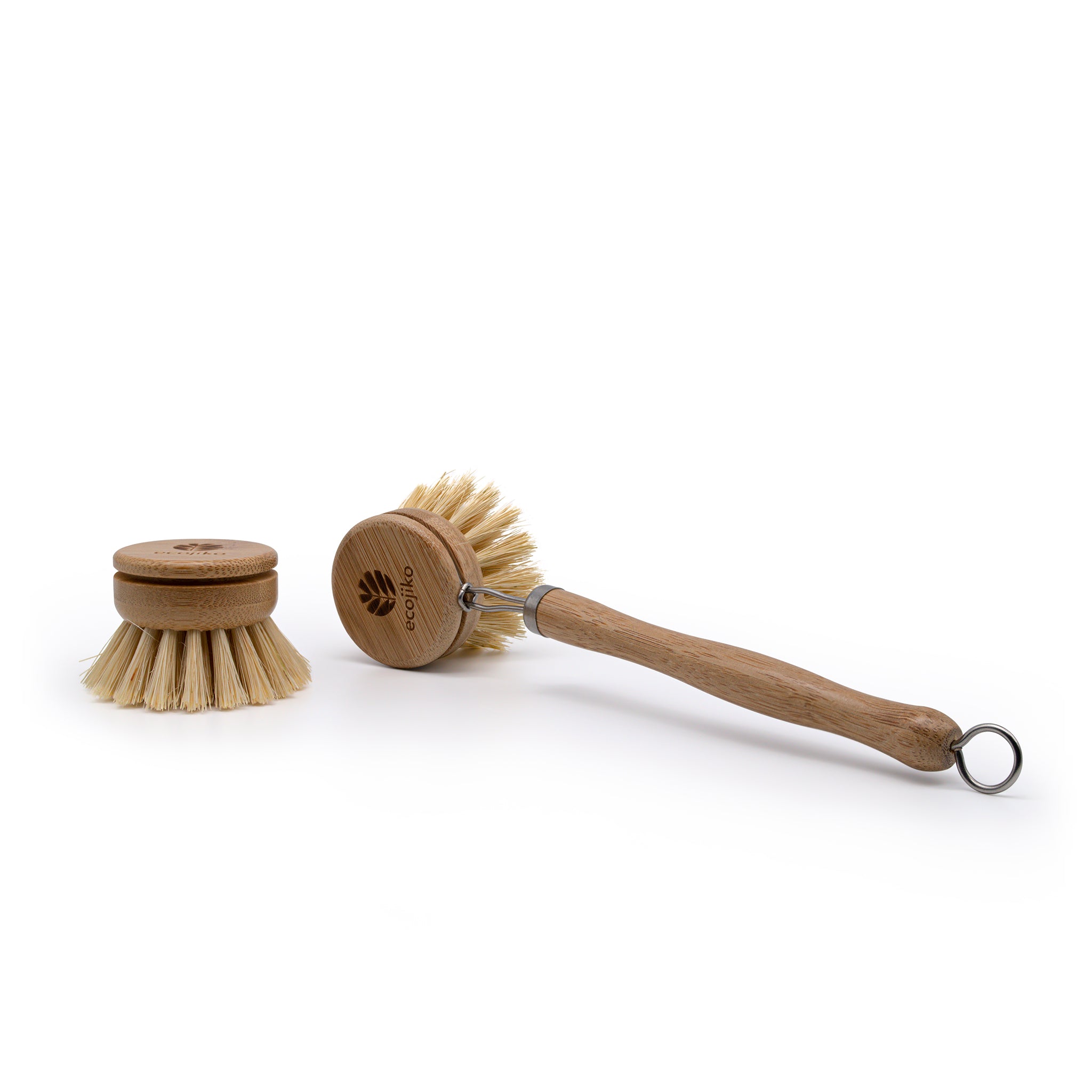 Bamboo dish brush lying next to one of the replacement bamboo and sisal heads