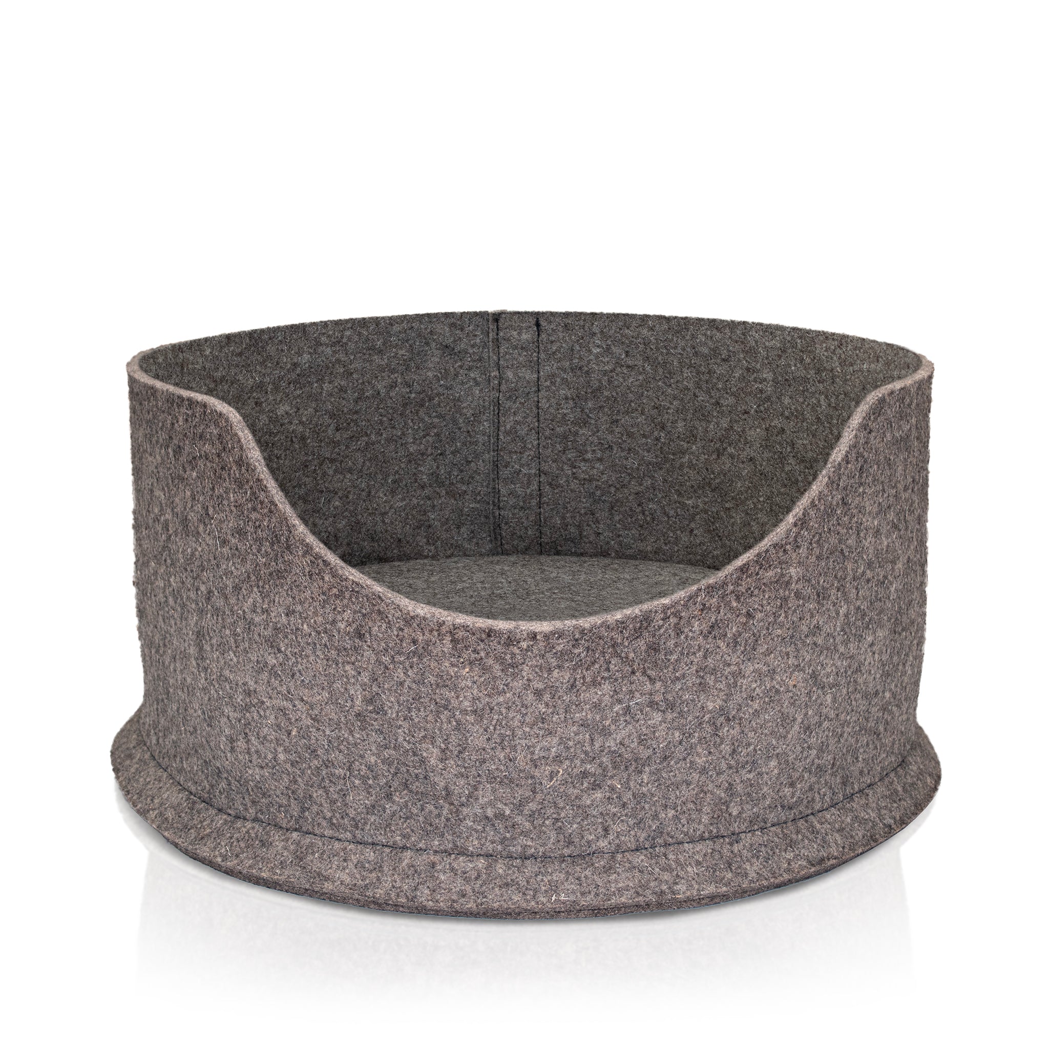 A Chimney Sheep Large PetSnug Cat Bed. Also known as a Chimney Sheep Large PetSnug dog bed. This is a wool felt snug bed, made of 100% natural sheep's wool. It is plastic free and pet safe. The pet sis upon a white background. It is 3D circular in shape with a dip in the centre to allow easy access for pets.