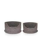 Two Chimney Sheep PetSnug Pet Beds. The small PetSnug is designed to be a cat bed, while the large PetSnug is desigfned to be a large cat or small wool dog bed. These are wool felt cozy beds, made of 100% natural sheep's wool. It is plastic free and pet safe. The pet beds sit upon a white background. It is 3D circular in shape with a dip in the centre to allow easy access for pets.