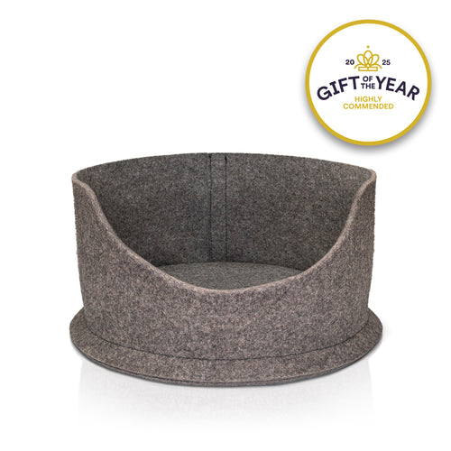 White cat lying in a grey felt pet bed with a 'Gift of the Year Highly Commended' badge.