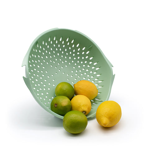 Colander on side with lemons and limes.