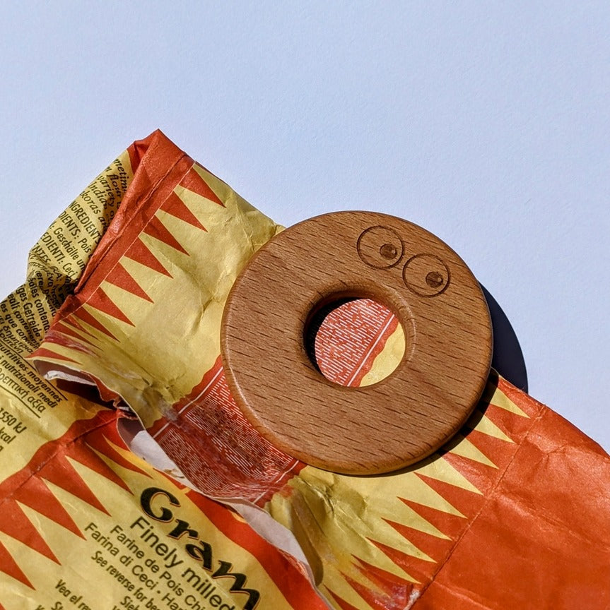 Wooden food bag clip forming tight seal on bag.