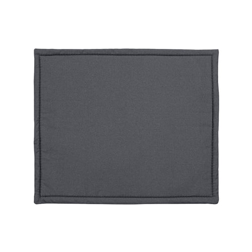 A black metal crate, with a green eco-friendly crate liner inside, filled with wool. The crate is placed on the grass at an angle. Inside the crate there is a black and white long haired border collie dog! The dog is laid up, alert staring off at an angle. The crate is placed at an angle.