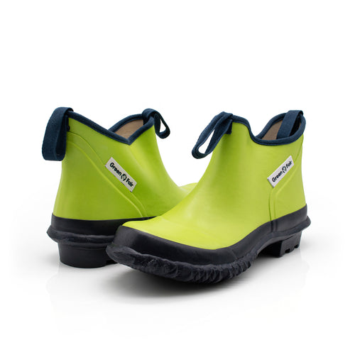 Pair of green rubber boots with black soles on a white background