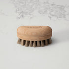 Wooden nailbrush with bristles on a marble background