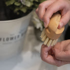 person cleaning their nails with wooden nailbrush and natural bristles. 