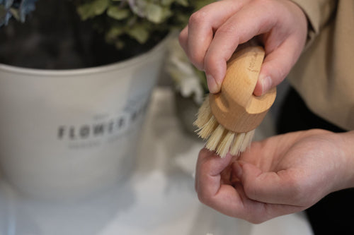 Wooden nailbrush with bristles on a marble background