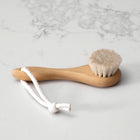 Natural wood and soft bristle hair brush for babies on a natural marble background