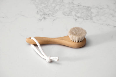 Natural wood and soft bristle hair brush for babies on a natural marble background