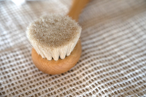 Natural wood and soft bristle hair brush for babies on a natural marble background