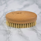 FSC and natural bristle vegetable scrubbing brush on marble background