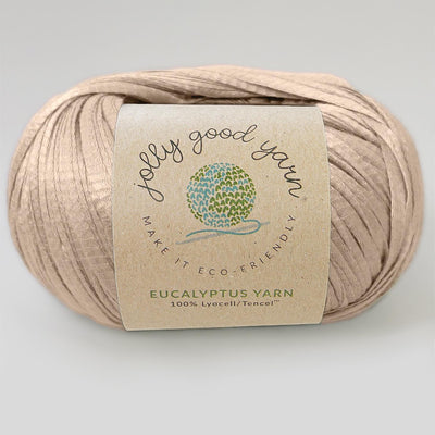 Yellow yarn ball with a label on a light gray background