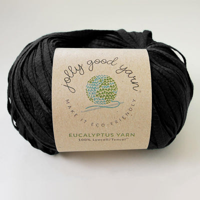Yellow yarn ball with a label on a light gray background