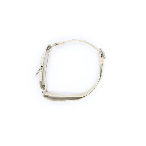 A natural jute hemp martingale style dog collar. The collar is made of woven hemp. The collar is stood on a white background with the two silver metal buckles and silver metal ring visible