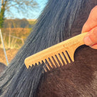 Wooden comb for grooming bay horse, part of the horse grooming kit