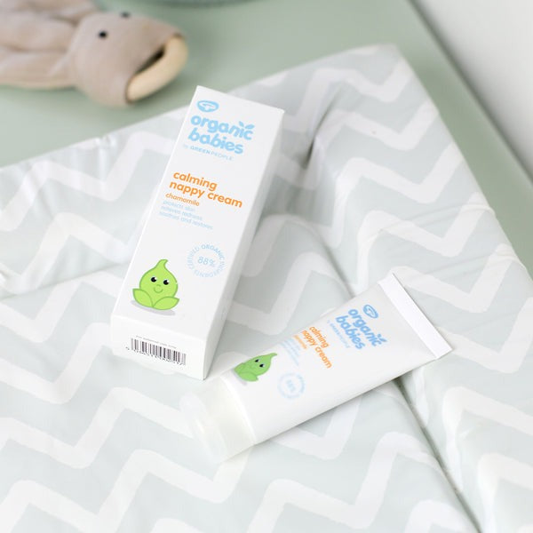 Calming nappy cream for babies made from 88% certified organic ingredients. Shown on a baby changing mat. 