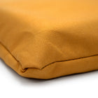 Close-up of a mustard yellow fabric on luxury dog bed made of organic fabric filled with sheep wool felt on a white background