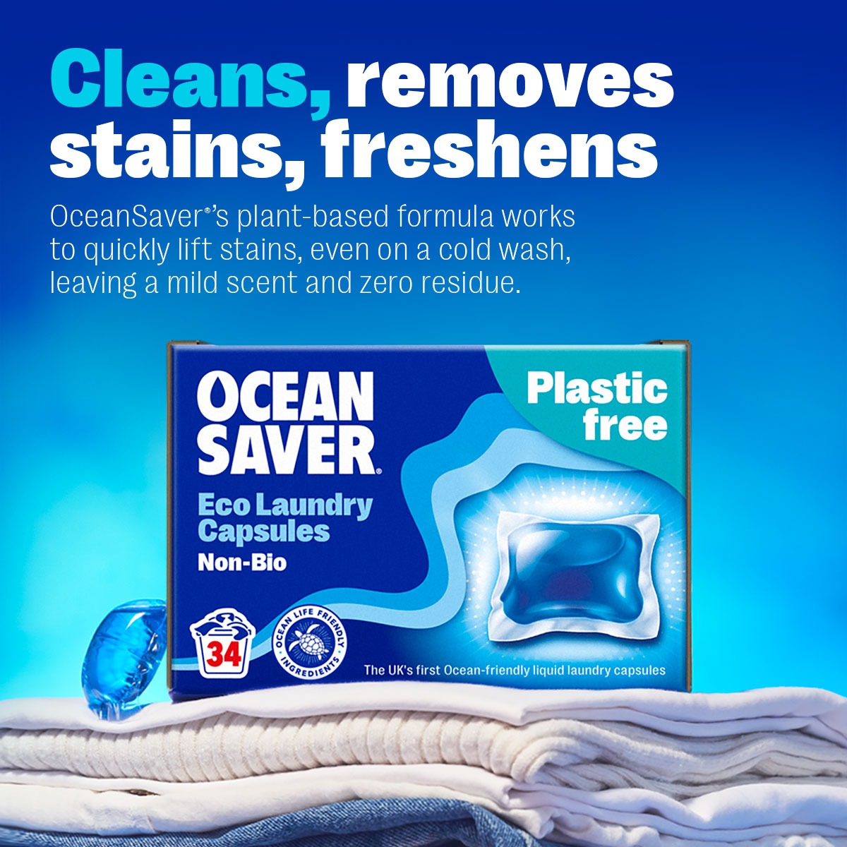 Box of Ocean Saver laundry detergent eco-friendly capsules on a pile of clean laundry.