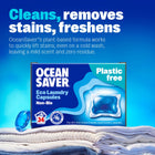 Box of Ocean Saver laundry detergent eco-friendly capsules on a pile of clean laundry.