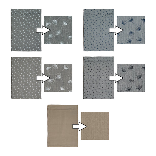 A black and white border collie sits upon a Chimney Sheep Luzury wool dog bed in the grey and white floral pattern. The wool dog bed sits upon some grass as the collie looks to the left with erect ears.