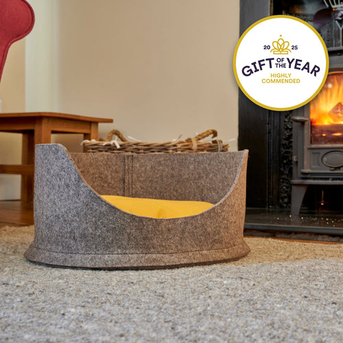 White cat lying in a grey felt pet bed with a 'Gift of the Year Highly Commended' badge.