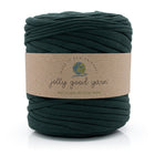 A skein of dark forest green recycled textile yarn with a brown paper label reading 'jolly good yarn' on a white background.