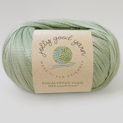 Yellow yarn ball with a label on a light gray background