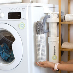 PlanetCare Microfiber Filter attached to a white washing machine, the filter is being changed and the used one removed. thumbnail