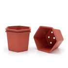 Three hexagonal plant pots with one on it's side. 